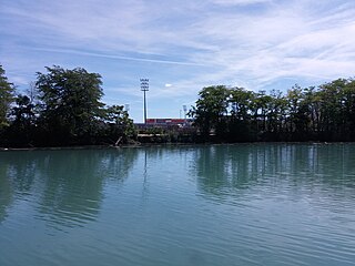 Blick über den Canal de Jonage auf die Pferderennbahn Carré de Soie