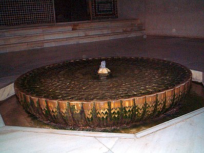Water flows out over the corrugated sides of a fountain, 1360s Patio del Cuarto Dorado, Alhambra, Granada, Spain (wet)