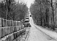 Stacks of jerry cans line a road.