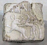 Fighting scene between a beast and a man with horns, hooves and a tail, who has been compared to the Mesopotamian bull-man Enkidu.[68][69][70] Indus Valley Civilisation seal.