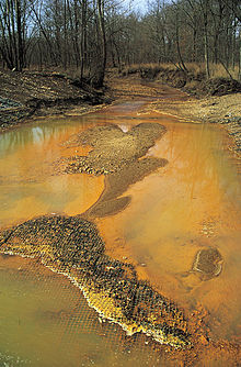 A sacrifice zone where Iron hydroxide precipitate from coal mining has damaged a stream and surrounding area