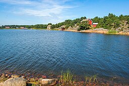 Hummersö. Vy från skäret Åttskär i Bofjärd. Till vänster ett par av bondgårdarna, till höger uppe på berget det före detta missionshuset och däremellan den före detta butiken, numera Galleri Berghäll. 7 augusti 2009.