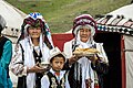 Kyrgyz women and child offering bread and salt on the opening of the National Horse Games,