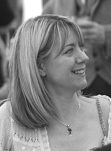 Black and white head and shoulders close up of a female smiling and looking to her left