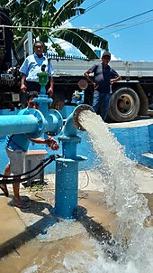 Disconnected blue water pipe discharging water at around head height