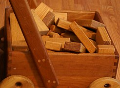 Wooden unit blocks, a type of toy block, in a wooden wagon