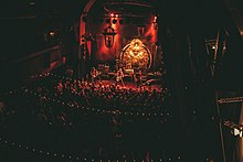 A thin, ornate room packed with fans