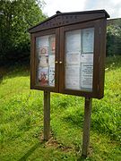 The village notice board which stands outside the boundary wall of the parish church of Our Lady and Saint Margaret.