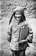 A Salar Muslim Girl Holds a Wooden Plate Written Arabic Verses of the Quran.jpg