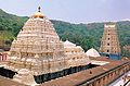 Ornate, light-coloured buildings with forest in background]]