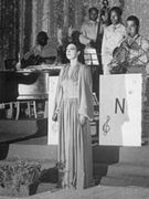 Josephine Baker sings the National Anthem as the finale to the show held in the Municipal Theater, Oran, Algeria, N. Africa. The band is directed by T/Sgt. Frank W. Weiss. May 17, 1943.