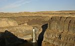 A tall, thin waterfall in a barren canyon