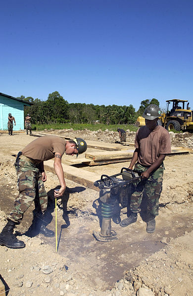 File:US Navy 060223-F-2326B-078 U.S. Navy Seabee Builder Construction Marc Verno measures the trench depth as Construction Electrician 3rd Class Justin Nice operates the wacky packer.jpg