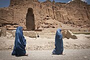 Two women walk past the huge cavity where one of the ancient Buddhas of Bamiyan used to stand, June 17, 2012. The monumental statues were built in A.D. 507 and 554