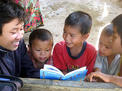 Un collégien fait la lecture à des élèves plus jeunes