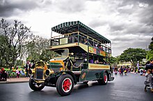 A green turn-of-the-20th-century-style double-decker bus