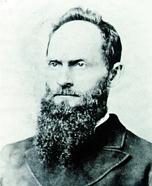 Black-and-white headshot photo of Mackay facing left