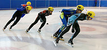 Plusieurs patineurs se suivant dans un virage.