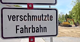 Staßenschild - Verschmutzte Fahrbahn - Bagger in Sebnitz - Grenze.jpg