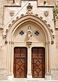 Gotisches Eingangsportal der Kirche San-Pere Petra (Mallorca) mit filigranen Details und einer Skulptur aus Marès. Das Portal wurde teilweise mit Kunststein ergänzt.