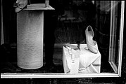 Gun holster makes an ironic fashion statement in the window display of an erstwhile shoe shop.