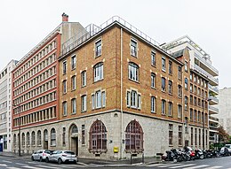 Façade en briques rouges du siège de l'association, un immeuble de cinq étages à Paris.