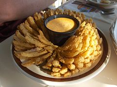 A blooming onion with dipping sauce