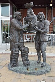 Bronze statue depicting Bernie Parent and Bobby Clarke dressed in hockey equipment and uniforms, together holding up the Stanley Cup trophy