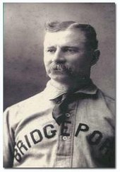 A baseball player is shown in uniform from the chest up, with the player looking slightly to his right