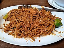 A plate of Malaysian mee mamak with an assortment of toppings