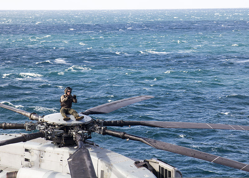 File:A U.S. Marine assigned to Marine Medium Tiltrotor Squadron (VMM) 266, 26th Marine Expeditionary Unit (MEU) signals fellow Marines while sitting atop a CH-53E Super Stallion helicopter on the flight deck of 131104-M-HF949-006.jpg