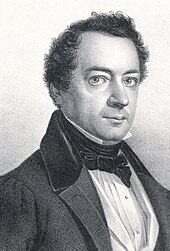 Photograph of a lithograph. It shows the head and shoulders of a middle-aged man dressed formally, and is wearing a coat, a white shirt with a high collar, and a bow tie.