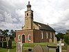 A Georgian style brick church seen from the southwest with a porch protruding in the foreground, a slim tower topped by a rotunda, and the body of the church extending beyond