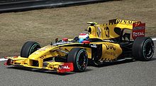 Vitaly Petrov driving a yellow, black and red Renault Formula One car in 2010