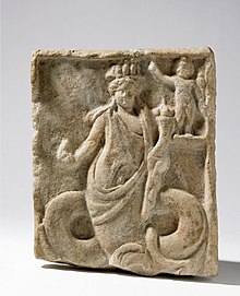 Rímsky mramorový reliéf (1. storočie) z Naukratisu zobrazujúci gréckeho boha Dionýza s hadím telom a egyptskou korunou.