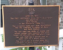 Bronze plaque with light-colored raised lettering on a dark-colored background