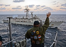 Rear Adm. Brad Williamson waves to the departing Spanish navy frigate ESPS Reina Sofia. (15932199665).jpg