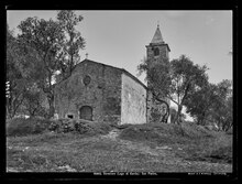 Schwarz-weiß Fotografie einer steinernen Kirche mit schlankem spitzem Kirchturm