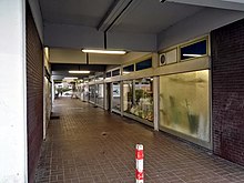 Photographie d'un couloir avec une porte vitrée sur la droite.