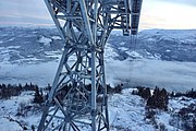 Heisen løfter passasjerene over 750 høydemeter. Banen er 2020 meter lang[2] og har tre store master. Bildet er tatt fra en gondolkabin ved øvre mast og viser panoramautsikt over Vossavangen og Vangsvatnet (under tåka) med Hardanger bak. Foto: November 2019