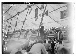 Woodrow Wilson on a stage with many other people