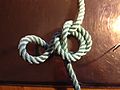 Step 3 of tying Cross constrictor knot: simple knot side loop folded over the middle loop