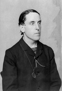 Half-length portrait photograph of Dr. Edward Bibbins Aveling, seated, facing right