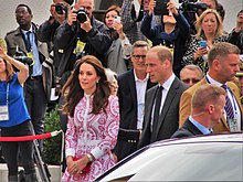 Catherine and William walk past a group of photographers