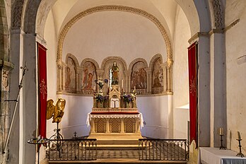 Abside românica do início do século XII com murais do século XIV apresentando cenas do martírio de Santa Bárbara, na igreja de Notre Dame de Savigny, Mancha, França. Santa Bárbara é uma das três virgens mártires do grupo de catorze santos auxiliares. Sua associação com o raio que matou seu pai fez com que ela fosse invocada contra raios e fogo; por associação com explosões, ela também é a padroeira da artilharia e da mineração. Seu dia de festa para os católicos romanos e para a maioria dos anglicanos é 4 de dezembro. Ela é mencionada no Martirológio Romano, que, além dela, lista outras dez santas mártires chamadas Bárbara. (definição 5 439 × 3 626)