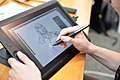 A person drawing on a Cintiq tablet