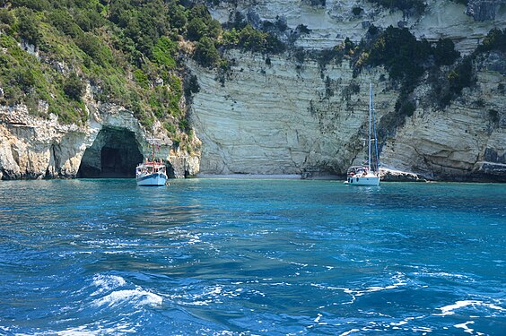 Boats sailing near one of the Blue Caves of Paxi, in the Ionian Sea.