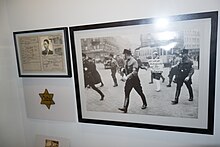 Nazis (SS men) tormenting Jews in germany ("Ich werde mich nie mehr bei der Polizei beschweren") Yellow Star cloth badge ("Jude") ID card with "J" Münchner Stadtmuseum 2014.jpg