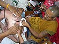 Hlwong Pi Pant tattooing a yant in Ang Thong Province.