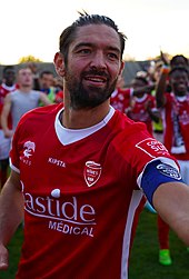 Photographie de face de Benoît Poulain avec le maillot et le brassard du capitaine de Nîmes Olympique.